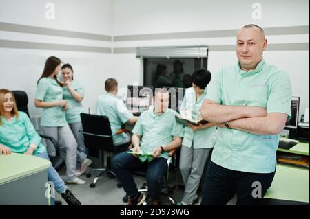 Thème médical .Portrait du médecin avec presse-papiers contre un groupe de médecins se rencontrant dans le bureau de l'irm au centre de diagnostic de l'hôpital. Banque D'Images