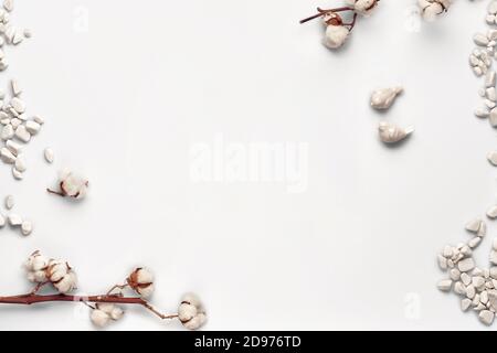 Fleurs de coton, pierres de mer et deux petits oiseaux en céramique isolés sur fond blanc. Gros plan, espace de copie, maquette. Vue de dessus, plan d'appartement Banque D'Images