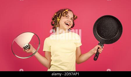 juste inspiré. petite femme tient la poêle. cuisine dans la cuisine. concept de ménage. cuisine pour enfants à la maison. enfance heureuse. jeune enfant joyeux avec des pillards. ménage de l'enfance. Banque D'Images