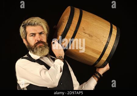 homme vigneron. homme barbu explorez le goût du vin au restaurant. Contrôle de la couleur et des sédiments du vin. Dégustation de vins. Le sommelier qualifié masculin estime la boisson alcoolisée. Le vin dans le baril. Banque D'Images