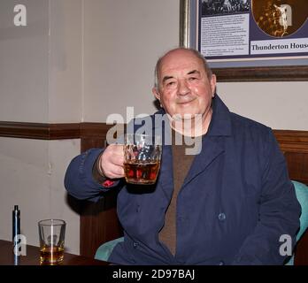 Muckle Cross, High Street, Elgin, Moray, Royaume-Uni. 2 novembre 2020. ROYAUME-UNI. Eric Thompson ayant sa pinte et un DRAM de whisky. Credit: JASPERIMAGE / Alamy Live News Banque D'Images