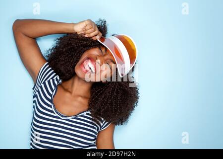 Portrait en gros plan d'une jeune femme afro-américaine heureuse capuchon sur fond bleu
