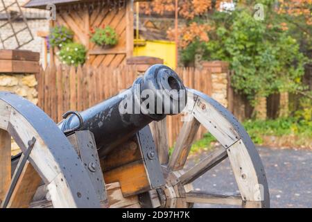 Les vieux canons en laiton dans le champ de bataille.vieux canons en métal debout sur deux supports en bois sur une pelouse ou un champ herbacé vue par une belle journée d'été Banque D'Images