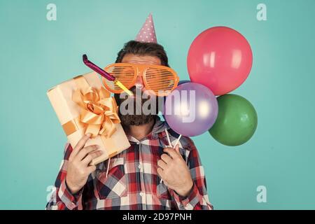 Votre commande est prête. Brutal homme en fête. Drôle d'homme dans un chapeau d'anniversaire. Joyeux Noël. Fête de la fête, fête, fête, fête, fête, fête, ballons, fête, anniversaire, gestionnaire d'événements avec boîte cadeau. Banque D'Images