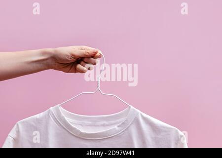 Image rognée de la main de la femme avec un t-shirt blanc Banque D'Images