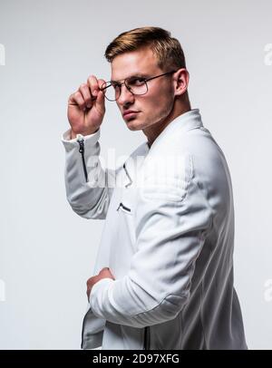 Beau homme avec les cheveux blonds courts dans la mode portez des lunettes correctrices avec regard sérieux isolé sur blanc, vue. Banque D'Images