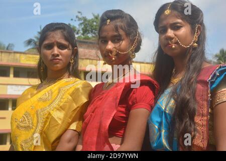 Trois jeunes filles bengali portant une saree et des bijoux comme les anneaux de nez boucles d'oreilles collier maang tika avec de longs cheveux noirs, focalisation sélective Banque D'Images