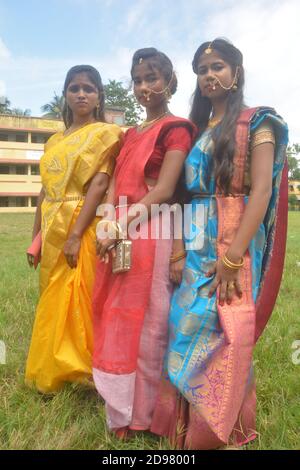 Trois jeunes filles bengali portant une saree et des bijoux comme les anneaux de nez boucles d'oreilles collier maang tika avec de longs cheveux noirs, focalisation sélective Banque D'Images