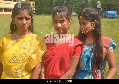 Trois jeunes filles bengali portant une saree et des bijoux comme les anneaux de nez boucles d'oreilles collier maang tika avec de longs cheveux noirs, focalisation sélective Banque D'Images