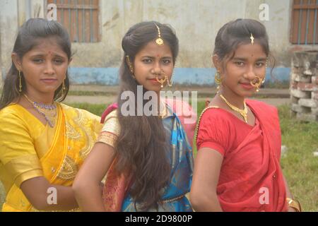 Trois jeunes filles bengali portant une saree et des bijoux comme les anneaux de nez boucles d'oreilles collier maang tika avec de longs cheveux noirs, focalisation sélective Banque D'Images