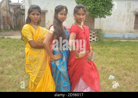 Trois jeunes filles bengali portant une saree et des bijoux comme les anneaux de nez boucles d'oreilles collier maang tika avec de longs cheveux noirs, focalisation sélective Banque D'Images