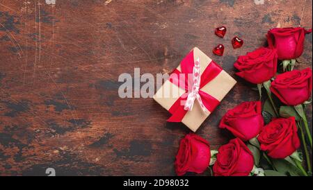 Roses rouges, boîte cadeau et coeurs décoratifs sur fond de bois. Bannière horizontale de la Saint-Valentin - image Banque D'Images
