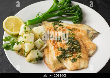 Deux filets de plie cuits d'une plie, Pleuronectes platessa, qui a été prise dans le chenal anglais. Ils ont été trempés dans de la farine et frits et s. Banque D'Images