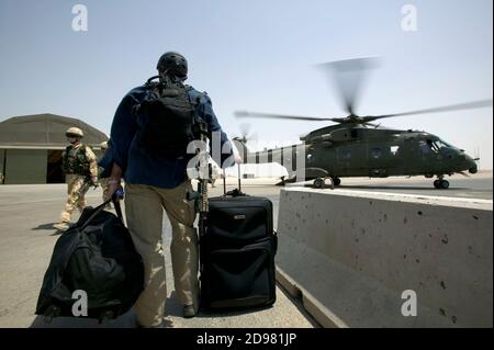 Un garde de sécurité privé se prépare à monter à bord d'un hélicoptère britannique. Pour des raisons de sécurité, la plupart des déplacements personnels se déplacent par avion plutôt que par route. Banque D'Images