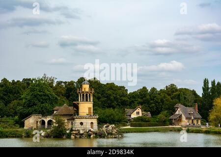 Versailles, France - le 28 août 2019 : la Tour Marlborough et son étang dans le hameau de la Reine au domaine de Marie-Antoinette près du château de Versailles. Banque D'Images