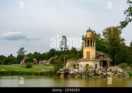 Versailles, France - le 28 août 2019 : la Tour Marlborough et son étang dans le hameau de la Reine au domaine de Marie-Antoinette près du château de Versailles. Banque D'Images