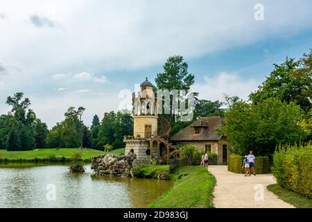 Versailles, France - le 28 août 2019 : la Tour Marlborough et son étang dans le hameau de la Reine au domaine de Marie-Antoinette près du château de Versailles. Banque D'Images