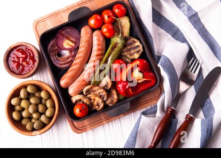 Légumes grillés avec saucisses, tomates, poivrons et champignons sur un barbecue Banque D'Images