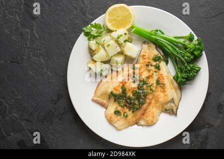 Deux filets de plie cuits d'une plie, Pleuronectes platessa, qui a été prise dans le chenal anglais. Ils ont été trempés dans de la farine et frits et s. Banque D'Images