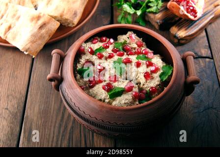 Le Satsivi aux graines de grenade et à la coriandre est une cuisine géorgienne traditionnelle. Les plats géorgiens sur fond de bois Banque D'Images