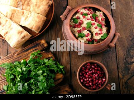 Le Satsivi aux graines de grenade et à la coriandre est une cuisine géorgienne traditionnelle. Les plats géorgiens sur fond de bois Banque D'Images