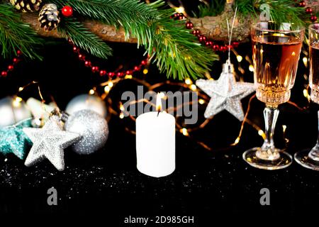Concept vacances nouvel an. Décor du nouvel an - verres à champagne, jouets de Noël, un sapin de Noël avec des décorations, une bougie pour faire un vœu Banque D'Images