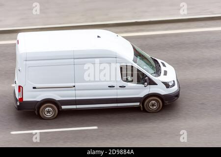 Un minibus blanc se rend sur l'autoroute de la ville Banque D'Images