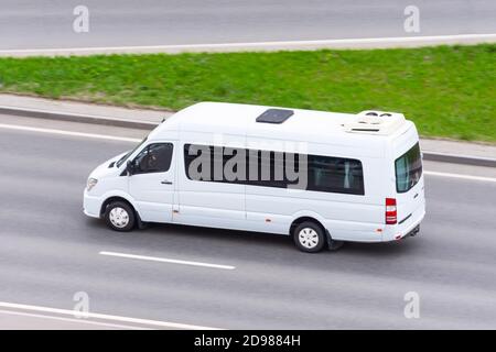 Un minibus blanc se rend sur l'autoroute de la ville Banque D'Images