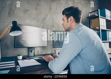 Vue arrière de la colonne vertébrale photo d'un spécialiste informatique spécialisé bureau assis en tapant le code de test de travail de données de site web écran de bureau moderne Banque D'Images