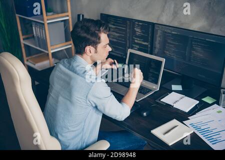 Photo du côté profilé avec vue en grand angle de type il spécialiste assis bureau tenir lunettes travail à la maison ordinateur tests freelance erreur de débogage du site web dans Banque D'Images