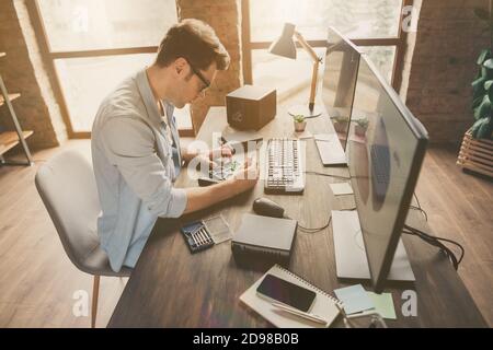 Profil vue de côté de son beau attirante concentré qualifié Un homme intelligent qui répare les pièces d'un PC sur une table processus de bureau chez modern Banque D'Images