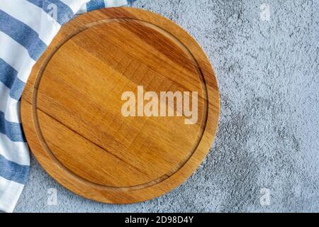 Planche à découper ronde en bois sur fond bleu-gris avec un copie de l'espace Banque D'Images