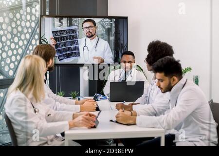 Vidéo-conférence en ligne, télémédecine, distance sociale, conférence Web. Équipe de médecins multiethniques sur la vidéoconférence médicale avec jeunes Banque D'Images