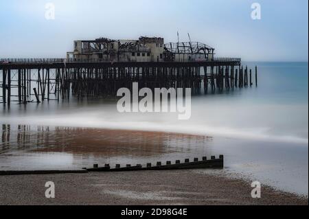 Vue monochrome du Gaunt et de l'épave tordue de Hastings Pier dans East Sussex, Angleterre, Royaume-Uni, photographiée sept mois après le feu dévastateur de 2010. La jetée victorienne, ouverte en 1872, a accueilli d'importants spectacles de rock et de pop dans les années 1960, dont Pink Floyd, Jimi Hendrix, les Rolling Stones et l'OMS. Un incendie a détruit le pavillon de la jetée Hastings de 2,000 places en 1972, la jetée a été fermée comme une structure dangereuse et l'incendie a détruit le 5 octobre 2010 ses bâtiments en bois restants. Les travaux de reconstruction ont été lancés en 2011 et la jetée a été rouverte en 2016. Banque D'Images