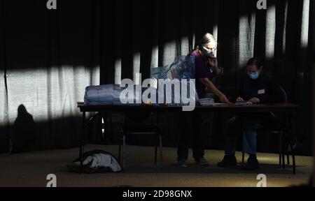 Racine, Wisconsin, États-Unis. 3 novembre 2020. Les employés du bureau du greffier de la ville sont mis en évidence par la lumière du matin au Festival Hall de racine, Wisconsin, le jour de l'élection, le 2 novembre 2020. (Image de crédit : © Mark HertzbergZUMA Wire) Banque D'Images