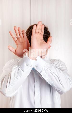 L'homme montre un geste de refus avec les mains près du mur Dans la chambre Banque D'Images