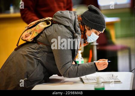 Montpelier, Vermont, États-Unis. 3 novembre 2020. Un électeur s'enregistre aux urnes à l'hôtel de ville de Montpelier, VT, pour voter à l'élection 2020. Les électeurs se sont rendus aux urnes malgré une tempête de neige au début de la saison qui a laissé plusieurs centimètres de neige neuve. Crédit : John Lazenby/Alamy Live News Banque D'Images