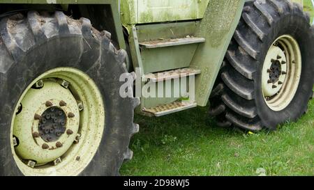 Gros plan des grandes roues noires du tracteur. Tracteur mercedes vert stationné dans le champ de l'agriculteur à Cambridgeshire, Royaume-Uni. Banque D'Images