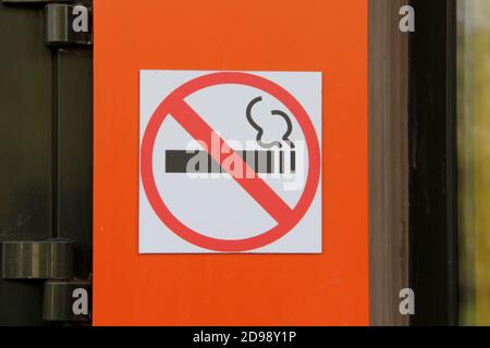 Panneau de non-fumeurs sur le mur orange, concept de soins de santé, renoncement au tabac. Fumer de la cigarette dans un cercle rouge barré. Banque D'Images
