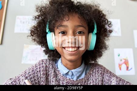Bonne fille africaine enfant port casque regardant l'appareil photo, tête de prise de vue. Banque D'Images