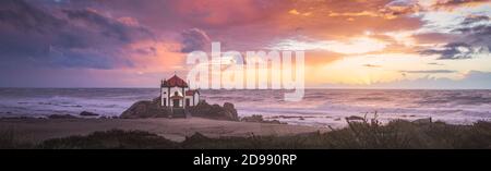 Coucher de soleil sur la plage avec une église sur la plage (Église de Senhor da Pedra) Banque D'Images