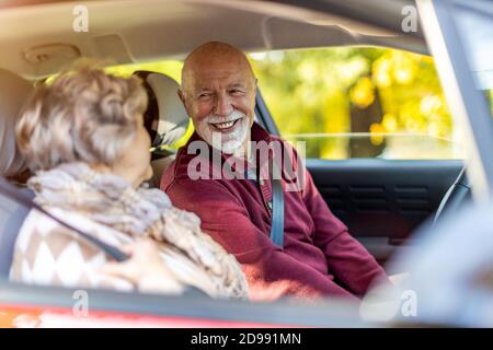 Heureux couple Senior voyageant dans leur voiture Banque D'Images