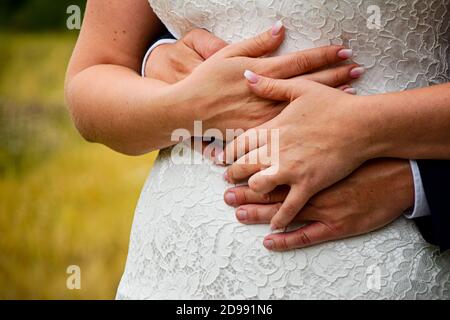 Les bras tiennent les mains à sa mariée lors d'un mariage en plein air Banque D'Images