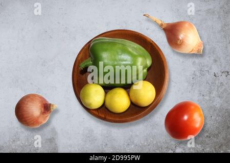 Vue de dessus des légumes frais; tomates, piment vert, citrons et ail sur fond de grunge gris Banque D'Images