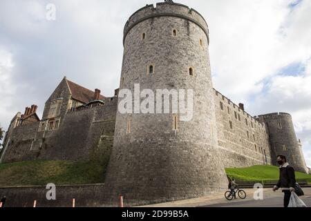 Windsor, Royaume-Uni. 3 novembre 2020. Un homme portant un visage couvrant passe devant le château de Windsor. Les entreprises locales se préparent pour le deuxième confinement national de l'Angleterre pour lutter contre la propagation du coronavirus, qui doit commencer le 5 novembre et durer quatre semaines. Crédit : Mark Kerrison/Alamy Live News Banque D'Images