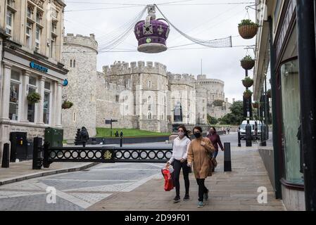 Windsor, Royaume-Uni. 3 novembre 2020. Les amateurs de shopping portant des couvre-visages passent devant le château de Windsor. Les entreprises locales se préparent à EnglandÕs deuxième confinement national pour lutter contre la propagation du coronavirus, qui doit commencer le 5 novembre et durer quatre semaines. Crédit : Mark Kerrison/Alamy Live News Banque D'Images