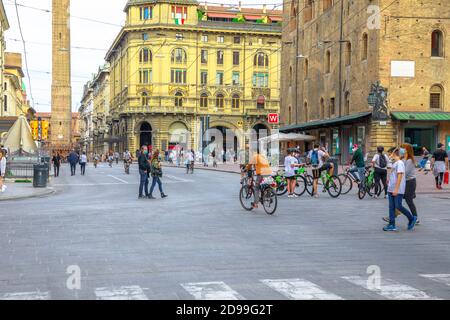 Bologna, Italie - 9 mai 2020: Familles italiennes avec les masques chirurgicaux de marche et de vélo d'équitation dans la rue Indipendenza avec deux tours sur le Banque D'Images