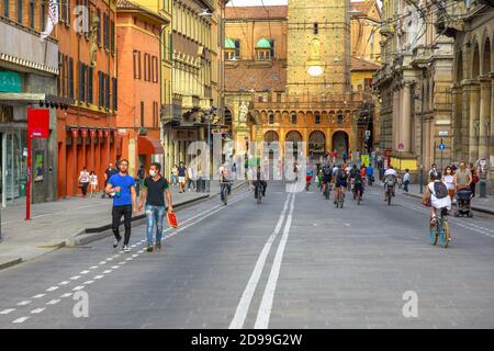 Bologne, Italie - 9 mai 2020 : familles italiennes avec masques chirurgicaux marchant et faisant du vélo sur la route de Rizzoli avec deux tours. Covid-19 temps avec Banque D'Images