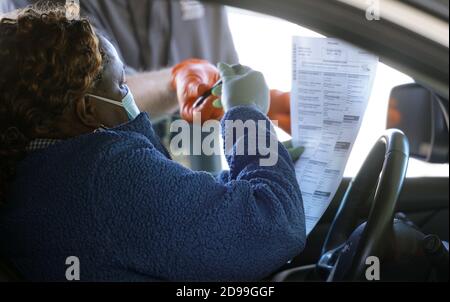 St Ann, États-Unis. 03ème novembre 2020. Une femme se déplace pour recevoir un bulletin de vote et un stylo pour voter dans la zone d'isolement du bureau des élections du comté de St. Louis le mardi 3 novembre 2020. Le comté de Saint-Louis a créé une zone spéciale pour les personnes qui votent, peut-être, COVID-19 ou qui sont en quarantaine. Photo par Bill Greenblatt/UPI crédit: UPI/Alay Live News Banque D'Images