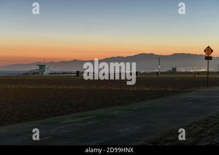 Coucher de soleil sur Venice Beach, Californie, tandis que le soleil se couche derrière les montagnes. Banque D'Images